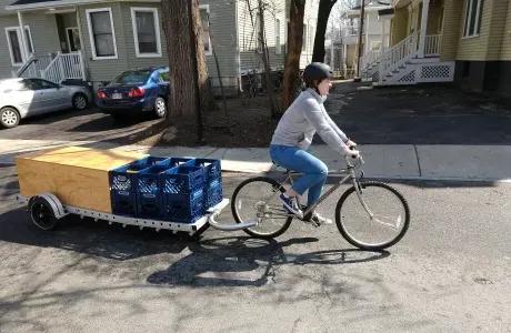 一名学生蹬着自行车，拖着便携式ParkKit