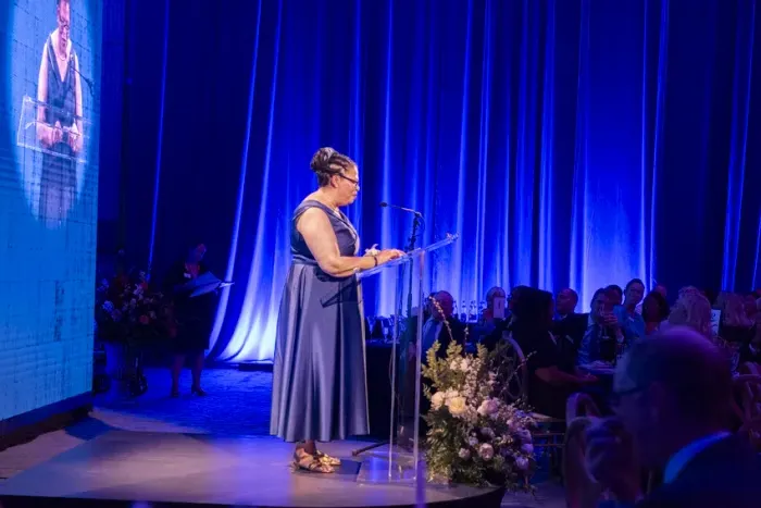 总统萨拉·威利-勒布朗顿站在颁奖台上发表讲话.