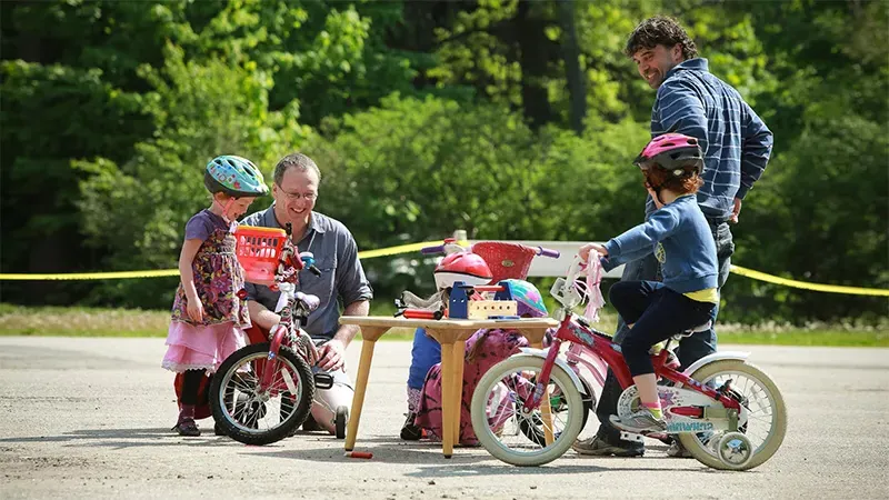 两个爸爸带着小孩子骑自行车
