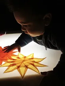 Small child arranging colored paper pieces
